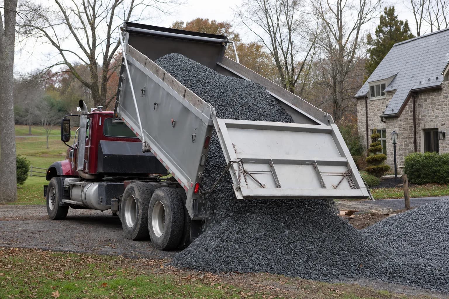 Dump truck delivering gravel to a residential property